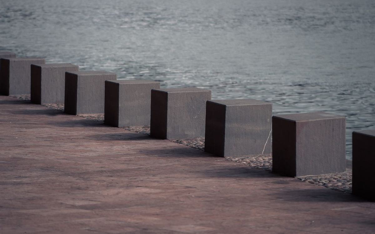 Large paved waterfront area with concrete bollards