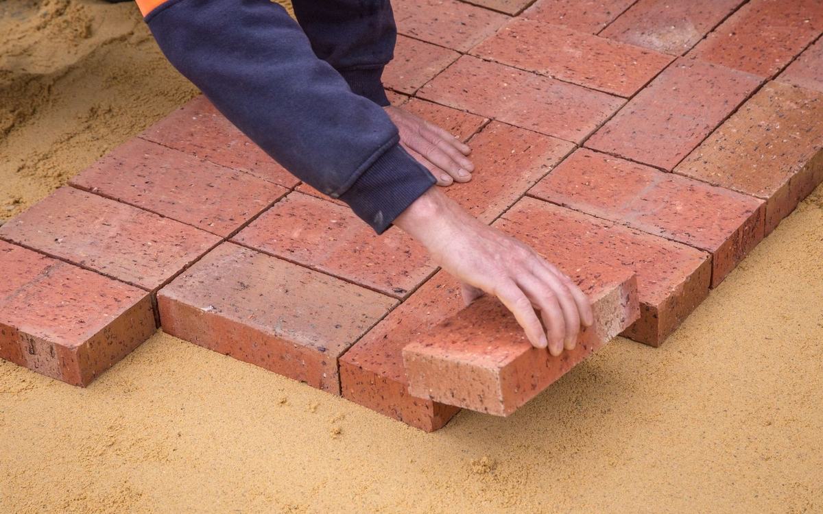 Paving blocks being laid by hand onto a screeded sand bed